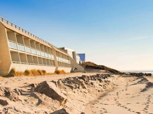 un edificio en la playa con huellas en la arena en ibis Thalassa Le Touquet, en Le Touquet-Paris-Plage