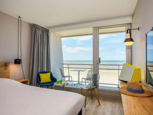 a hotel room with a bed and a view of the ocean at ibis Thalassa Le Touquet in Le Touquet-Paris-Plage