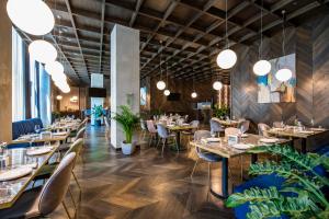 a restaurant with tables and chairs and potted plants at Tbilisi Philharmonic Hotel by Mercure in Tbilisi City