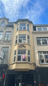 un grand bâtiment avec un panneau dans la fenêtre dans l'établissement Den Gulden Hoorn, à Anvers
