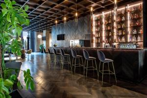a bar with leather stools in a restaurant at Tbilisi Philharmonic Hotel by Mercure in Tbilisi City
