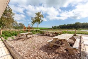 a picnic table and benches in a field at HarTeluk Afsluitdijk Zurich in Zurich