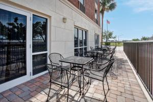 Hampton Inn & Suites Cape Coral / Fort Myers في كيب كورال: صف من الطاولات والكراسي على الفناء