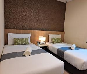 Postel nebo postele na pokoji v ubytování SCC Gateway Chinatown Hotel