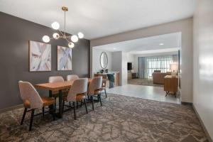 a dining room and living room with a table and chairs at Embassy Suites by Hilton Albuquerque in Albuquerque