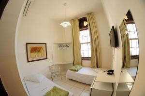 a living room with a bed and a mirror at Grande Hotel Renascença in Juiz de Fora