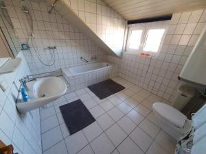 a bathroom with a sink and a tub and a toilet at Ferienwohnung in Rheinstetten +8 photos