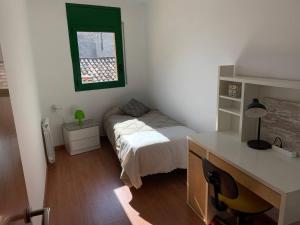1 dormitorio con cama, escritorio y ventana en ApartaMonti Dúplex, 