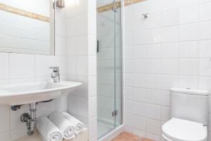 a bathroom with a sink and a toilet and a shower at Jardines del Sol in Playa Blanca