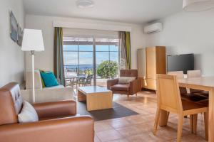 a living room with a couch and a table with a view at Jardines del Sol in Playa Blanca