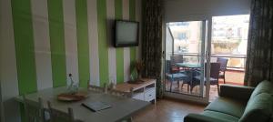 a living room with a table and a tv on the wall at Apartament a L’Estartit x 4 in Torroella de Montgrí +7 photos