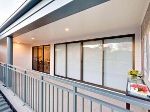 a balcony with windows and a table with flowers on it at ibis Styles Canberra Tall Trees in Canberra