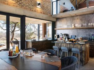 um restaurante com mesa e cadeiras e um bar em NAKO Safari Lodge em Dinokeng Game Reserve