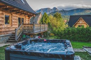 wanna z hydromasażem w ogrodzie obok domu w obiekcie TatryTop Osada Luxury Chalets Kościelisko w mieście Kościelisko