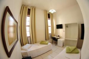 a room with a bed and a desk and a mirror at Grande Hotel Renascença in Juiz de Fora