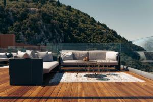 a balcony with a couch and a table and a mountain at Angsana Corfu Resort & Spa in Benitses