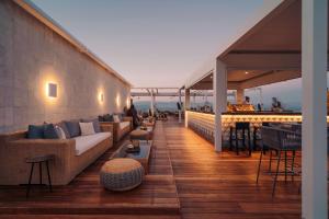 a rooftop patio with couches and tables on a building at Angsana Corfu Resort & Spa in Benitses