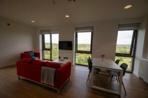 a living room with a red couch and a table at University of Galway Rooms in Galway