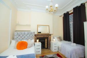 um quarto com 2 camas e uma lareira em Victorian Woods BnB em Londres