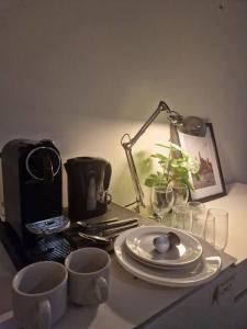 einen Tisch mit Teller, Tassen und einer Lampe in der Unterkunft Room 505 - Eindhoven by T&S in Eindhoven