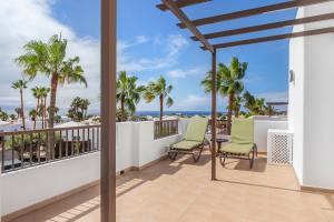 a balcony with two chairs and a view of the ocean at Jardines del Sol in Playa Blanca