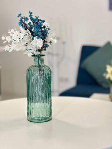 een groene vaas met bloemen op een tafel bij C’est la vie à Paris Apartment in Wenen