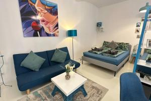 een woonkamer met een blauwe bank en een tafel bij C’est la vie à Paris Apartment in Wenen