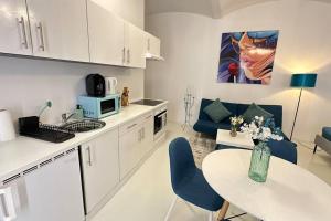 cocina y sala de estar con mesa y sillas azules en C’est la vie à Paris Apartment, en Viena