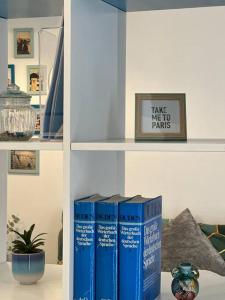 een boekenplank met boeken erop met een foto bij C’est la vie à Paris Apartment in Wenen