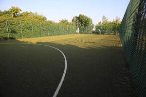 un campo da tennis con recinzione e rete di University of Galway Rooms a Galway