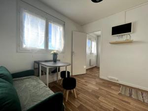 ein Wohnzimmer mit einem grünen Sofa und einem Tisch in der Unterkunft Le Thomeryon 10 minutes de Fontainebleau in Thomery