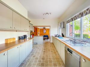 a kitchen with white cabinets and a large window at *RA9bC* For your most relaxed & Cosy stay + Free Parking + Free Fast WiFi * in Moortown