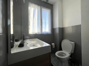 ein Bad mit einem WC, einem Waschbecken und einem Fenster in der Unterkunft Le Thomeryon 10 minutes de Fontainebleau in Thomery