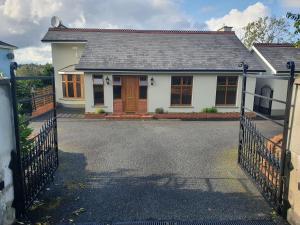 Uma casa branca com um portão à frente. em Hillcrest House em Carrick on Shannon