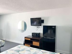 a room with a tv and a black refrigerator at Studio 6 Suites Opelousas, LA in Opelousas