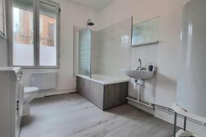 Un baño con bañera, lavabo e inodoro. en Chez K&D T2 Rouge Le Havre, en Le Havre
