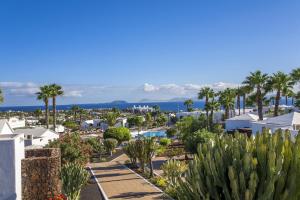 a view of a resort with palm trees and a pool at Jardines del Sol in Playa Blanca