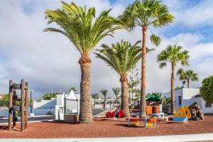a group of palm trees in a playground at Jardines del Sol in Playa Blanca