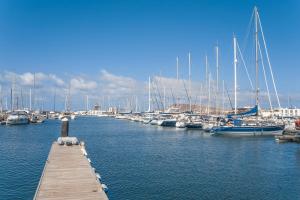 a dock with boats docked in a marina at Jardines del Sol in Playa Blanca