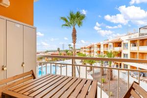 a balcony with a wooden bench and a palm tree at Vista la Gomera 2 in Callao Salvaje