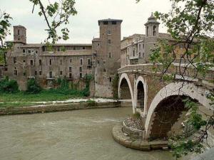 a stone bridge over a river in front of a building at Casina Roma, 2 min to Piazza Navona in Rome