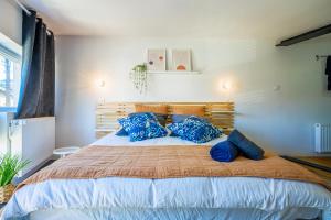 1 dormitorio con 1 cama grande con almohadas azules en Le Bourgeois, en Montbéliard