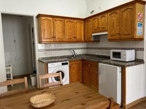 cocina con armarios de madera, lavadora y secadora en Orán Tenerife Suites Ap. 03 en Santa Cruz de Tenerife