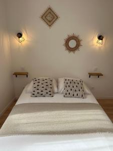 um quarto com uma cama com duas almofadas e um espelho em La Cabotte - Confort & Charme au Centre Historique - Balcon sur cour em Dijon