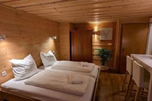 1 dormitorio con 1 cama en una pared de madera en großes Berg-Chalet in der Natur, en Bayrischzell