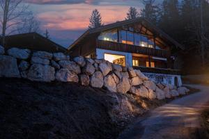 a large house with a stone wall in front of it at Einzigartiges Berg-Chalet in Alleinlage bis zu 21 Personen in Bayrischzell