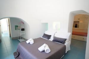een slaapkamer met een groot bed en handdoeken bij trullo lantane in San Michele Salentino