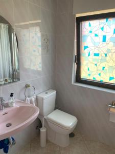 bagno con lavandino, servizi igienici e finestra di Jacaranda a Tacoronte