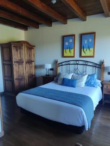 um quarto com uma cama grande e almofadas azuis em Hotel Rural Irati em Jaurrieta