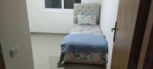 a small bed in a room next to a window at APPARTEMENT haut standing in O Ben Slimane